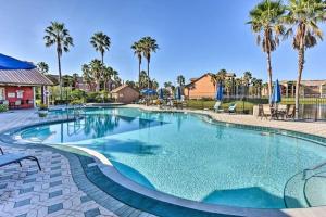 a large swimming pool in a resort with palm trees at Villa del Sol in Kissimmee