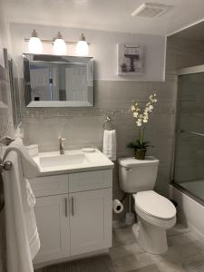 a white bathroom with a sink and a toilet at Villa del Sol in Kissimmee +7 photos