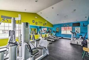 a gym with several tread machines in a room at Villa del Sol in Kissimmee