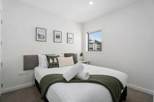 a bedroom with a large white bed with a window at Willow Lane in Albert Town +9 photos