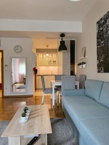 ザグレブにあるBest Times Apartmentの青いソファとテーブルのあるリビングルーム