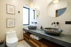 a bathroom with two sinks and a toilet at Ohana Villas in Santa Teresa Beach +61 photos