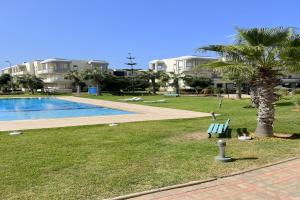 a park with a pool and a palm tree and buildings at Appartement Bahia Golf Beach Bouznika,Plage & Golf in Bouznika