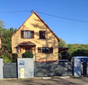 a house with a fence in front of it at Cottage champêtre in Marmoutier