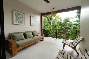 a living room with a couch and a balcony at Ohana Villas in Santa Teresa Beach