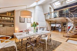Un comedor con una mesa y sillas blancas. en Le Loft Gallery YourHostHelper, en Touques