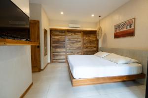 a bedroom with a bed and a flat screen tv at Ohana Villas in Santa Teresa Beach