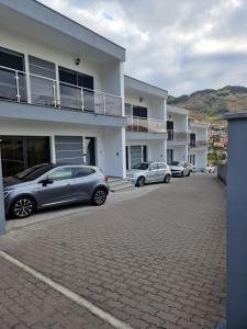 a parking lot with two cars parked in front of a building at Elegant Terraced Home with FREE Private Parking in Machico