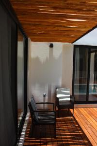 a porch with two chairs and a table and some windows at ¡Increible! Villa Luz de Luna in Akumal