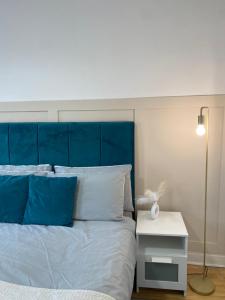 Bett mit blauem Kopfteil und einem weißen Nachttisch in der Unterkunft Modern Townhouse-Free Parking-Games Room-Fast W-iFi in Manchester