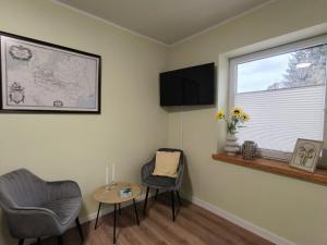 a room with two chairs and a table and a window at Stara oficyna in Siedlce