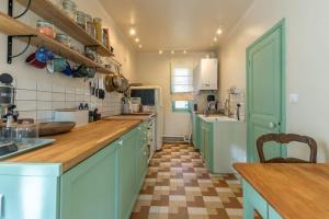 eine Küche mit blauen Schränken und einem karierten Boden in der Unterkunft La Belle France - Maison, Parking, à 200m du Cher in Saint-Georges-sur-Cher + 23 Fotos