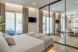 a bedroom with a large bed with glass walls at Central Sunny Loft with Plunge Pool in Athens