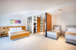 a bedroom with two beds and a desk and a bedskirts at Lei Hotel in Antalya