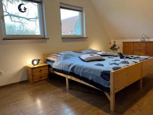 a bedroom with a bed with a blue comforter and a window at Landurlaub Mecklenburgische Seenplatte bei Waren Müritz in Schwarzenhof