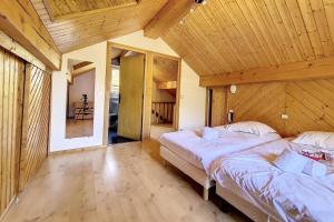 two beds in a room with a wooden ceiling at Chalet Les Lutins - Un cocon élégant au cœur des Allues MAE-4864 in Les Allues