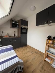 a small kitchen with black cabinets and wooden floors at Landurlaub Mecklenburgische Seenplatte bei Waren Müritz in Schwarzenhof