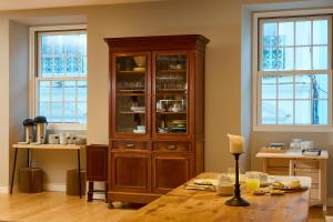 a large wooden hutch in a kitchen with a table at Matriz 55 in Ponta Delgada