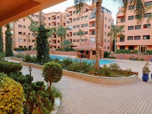 a courtyard with a pool in a large building at Family Apartment with Pool in Marrakech