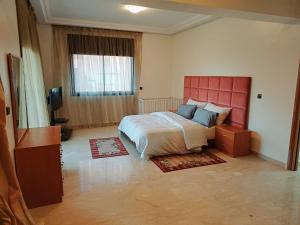 a bedroom with a large bed and a red headboard at Family Apartment with Pool in Marrakech +22 photos