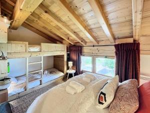 ein Schlafzimmer mit einem großen Bett in einem Zimmer mit Holzdecken in der Unterkunft Chalet Furz'a - Chalet Familial Cosy à Méribel MAE-7811 in Les Allues