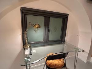 a glass table with a lamp next to a window at Farrose in Naples
