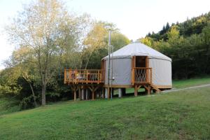 a yurt with a deck in the middle of a field at azyl glamp in Uście Gorlickie