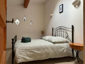 una camera con letto con struttura nera di La maison de Lalie a Lagrasse Altre 10 foto