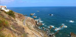 a road on the side of a cliff next to the ocean at Casa lucas in Almáciga