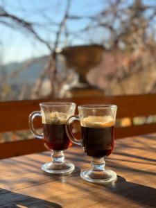 Zwei Gläser Kaffee stehen auf einem Holztisch. in der Unterkunft Сідус in Schidnyzja + 110 Fotos