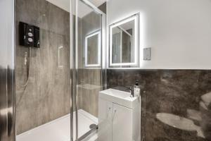 a bathroom with a shower and a sink and a toilet at Central Luxe - Brighton Central - 2 Beds in Brighton & Hove