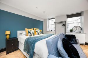 a bedroom with a large bed with a blue accent wall at Central Luxe - Brighton Central - 2 Beds in Brighton & Hove