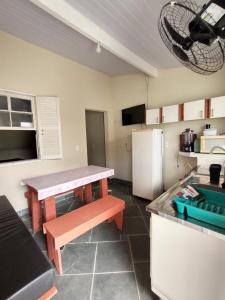 a kitchen with a table and a refrigerator at Praia de Boraceia casa 2 Bertioga in Bertioga