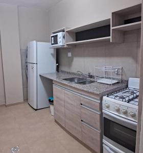 a small kitchen with a sink and a refrigerator at Departamento 1 Sarmiento in San Fernando del Valle de Catamarca