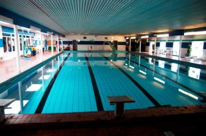 a large swimming pool in a large building at Nr. Nebel Overnatning Hostel in Nørre Nebel