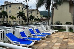 a row of blue and white chairs on a balcony at Cantinho dos Sonhos in Mangaratiba