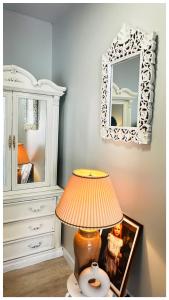 a lamp sitting on a table next to a mirror at The Stays - Private Cozy 2BHR Apt on main floor in Toronto