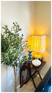 a table with a lamp and a plant on it at The Stays - Private Cozy 2BHR Apt on main floor in Toronto