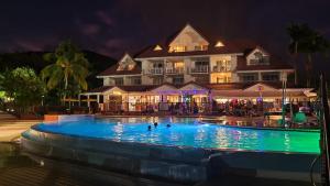 a large hotel with a swimming pool at night at Passion Caraïbe in Sainte-Luce