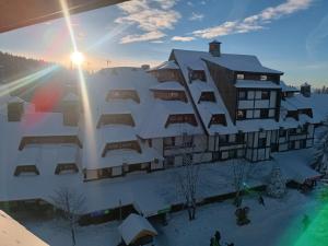 a building with snow on the side of it at Apartmani Iva Kop Konaci in Kopaonik