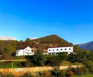 a house on top of a hill with a mountain at Guesthouse Tropojë e Vjeter in Tropojë