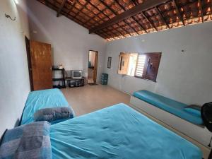 a bedroom with two blue beds and a window at Casa Praiana pé na areia Morro Branco in Beberibe +45 photos