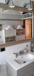 un bagno con un lavandino bianco e uno specchio di Casa Azalea a Lainate