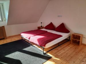 Un dormitorio con una cama con almohadas rojas. en BerlinDreams R144, en Berlín