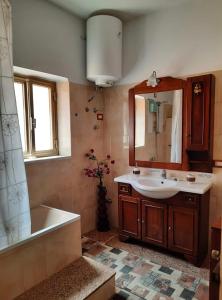 a bathroom with a sink and a tub and a mirror at Casa Nina in Cefalù