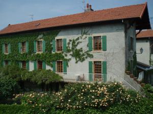 a white house with green shutters and flowers at Le Clos Des Fontaines in Thonon-les-Bains
