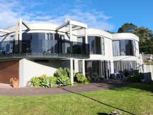 a large white house with a balcony at Oceanside Haven in Ohope Beach
