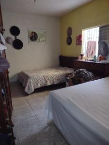 a bedroom with two beds and a window at Casa da Vovó in Praia Grande