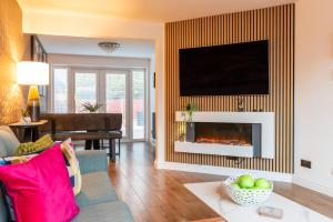 a living room with a couch and a fireplace at Triumph House in Hinckley