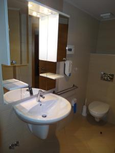 a bathroom with a sink and a toilet and a mirror at Apartment 116 in Jahorina +5 photos